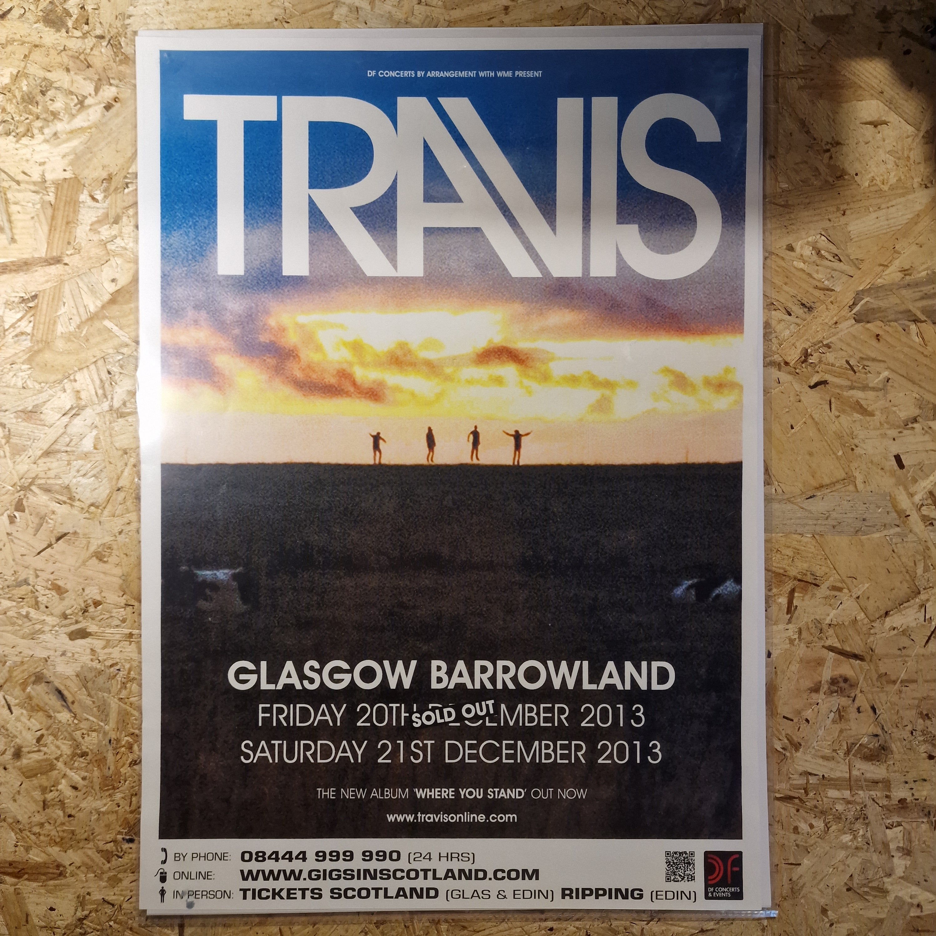 Travis concert poster on a wooden surface