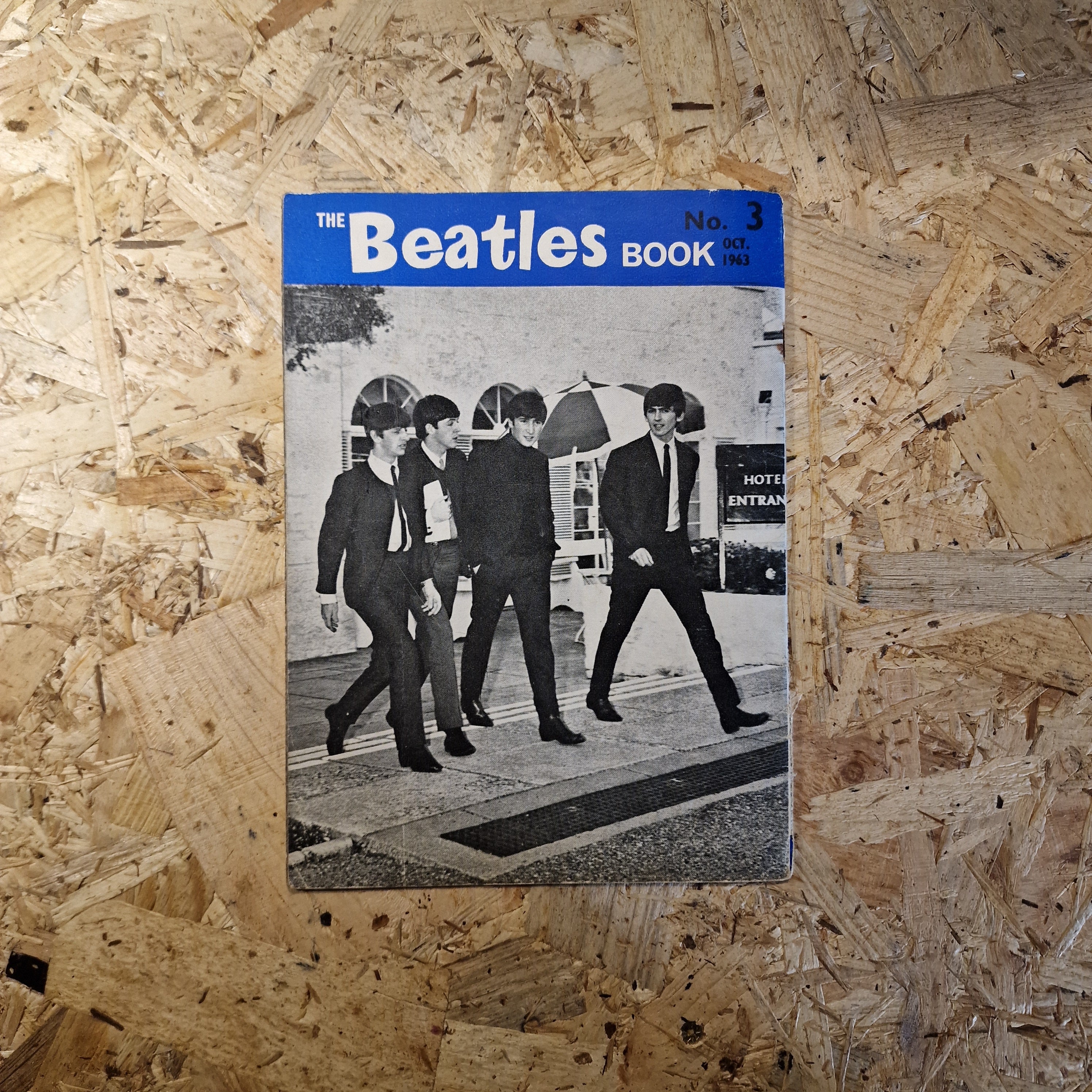 Vintage 'The Beatles' book cover on a wooden surface